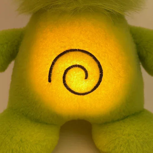 Glowing yellow plush toy with green fur and spiral design on belly